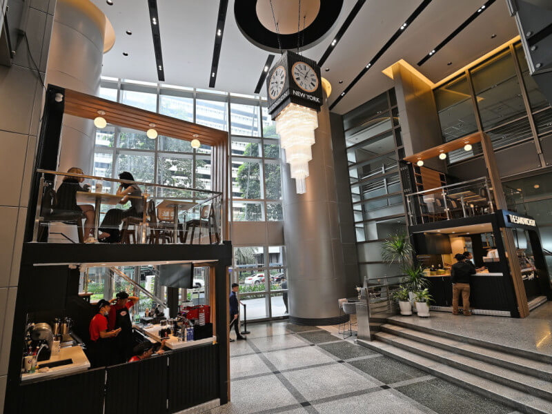 Robinsons Summit Center’s refurbished entrance hall, unveiled on Dec. 12, showcases marble floors, wood accents, and a stunning 10-meter-high atrium. Its centerpiece, a grand clock crowned by a crystal chandelier, displays time zones for Manila, Dubai, New York, and London./Photo from RLC 