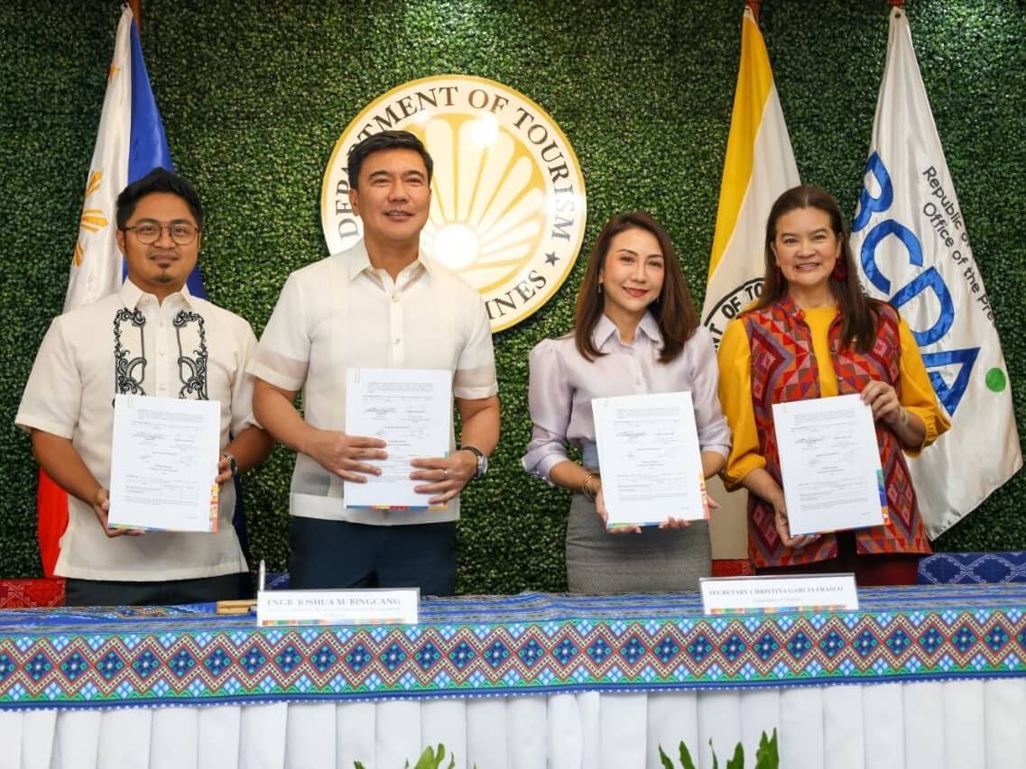 Tourism Secretary Christina Garcia Frasco and Bases Conversion and Development Authority (BCDA) President and CEO Joshua M. Bingcang sign a memorandum of understanding for collaborative efforts to strengthen sports tourism in New Clark City, Capas, Tarlac. Tourism Undersecretary for Halal tourism and Muslim concerns Myra Paz Valderrosa Abubakar and BCDA OIC senior vice president for conversion and development Mark P. Torres witness the signing. | Photo from BCDA&nbsp;