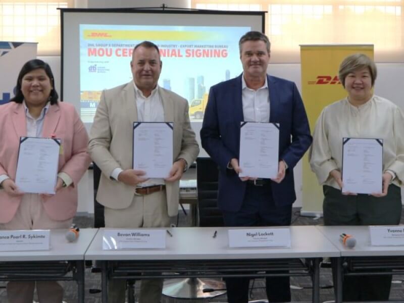 DTI-EMB Director Bianca Pearl R. Sykimte (2nd from left) and the DHL Group—represented by (3rd from left)  Bevan Williams, Nigel Lockett, and Yvonne Lee,—seal the partnership through an MOU signing, witnessed by DTI-EMB Assistant Director Maria Katrina D. Rivera and Emil Dabuet of DHL Express Philippines. | Contributed photo (Click to view full image)