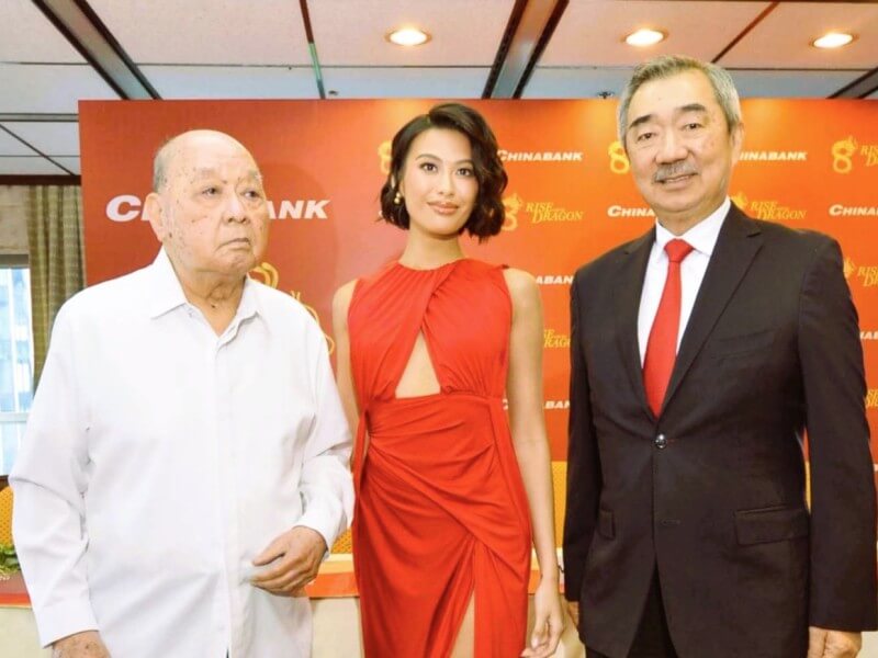 Gilbert U. Dee (left) and Chinabank chairman Hans T. Sy flank Michelle Dee during her 2024 appointment as the lender&rsquo;s first brand ambassador. Michelle is the granddaughter of former chairman Dee K. Chiong and grandniece of founder Dee C. Chuan./Photo from Chinabank's website&nbsp;