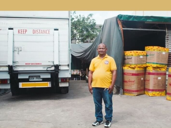 Joey Kaong stands beside his newly financed delivery truck, which has helped expand and strengthen his trucking operations in Las Pi&ntilde;as City. | Contributed photo