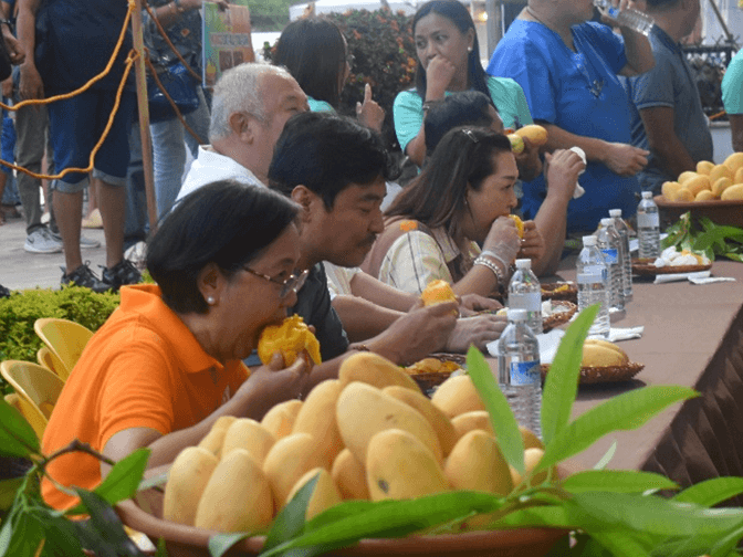 DTI Region 6 OIC Rachel N. Nufable joins fellow government officials in the “Mango Eat-All-You-Can” activity at the Guimaras Provincial Capitol Grounds during the Manggahan Festival on May 16, 2025./ Photo from DTI