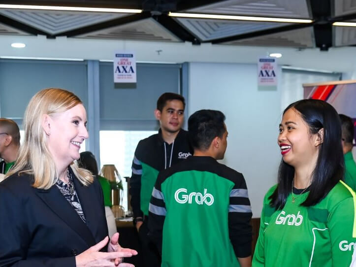 Sally O'Hara, CEO of AXA Southeast Asia and Korea, discusses the social protection benefits provided by the partnership with GrabFood cyclist Sarah Aguja and MOVE IT rider-partner Nigel Velasquez, focusing on enhanced social protection for two-wheel riders./ Photo from Grab Philippines (Click on the ​photo to view full image)