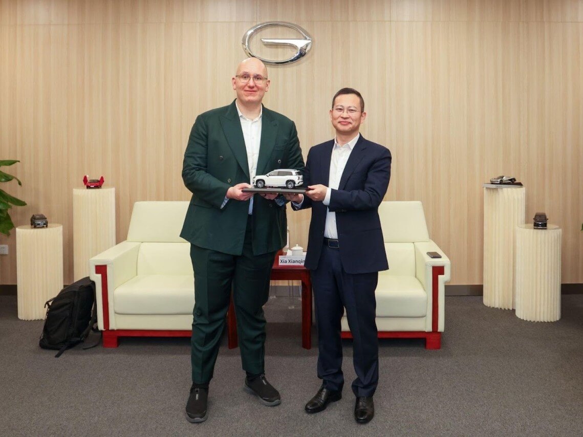 Philipp Kandal, chief product officer at Grab, receives a car model from Xia Xianqing, vice president of GAC Group. | Contributed photo