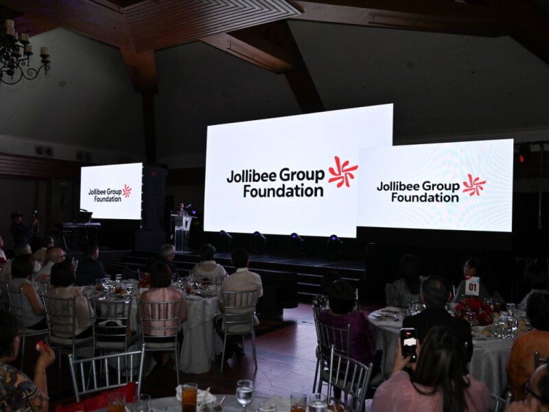 Jollibee Group Foundation chairman William Tan Untiong unveils the Foundation&rsquo;s refreshed logo during its 20th Anniversary celebration, symbolizing a renewed commitment to nourishing communities and expanding partnerships in the years ahead. | Contributed photo