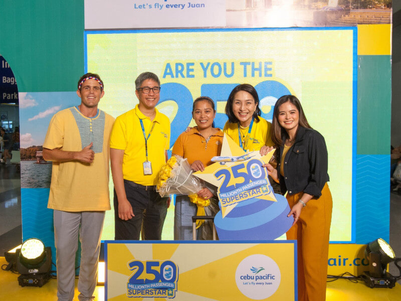 Russel Capaniarihan (center) receives P250,000 and 25 free flights as Cebu Pacific's 250 millionth passenger, joined by CEB president Xander Lao (second from left), CEB chief marketing and customer experience officer Candice Iyog (second to the right), and hosts Kyle 'Kulas' Jennermann (left) and Bea Binene (right)./Photo from Cebu Pacific 