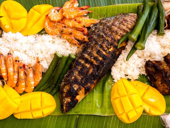 A vibrant feast of camaraderie and culture, the Filipino boodle fight brings people together over a bountiful spread of grilled meats, seafood, and rice — served on banana leaves and meant to be enjoyed hands-on, no utensils required./ Lifted from The MICHELIN Guide website