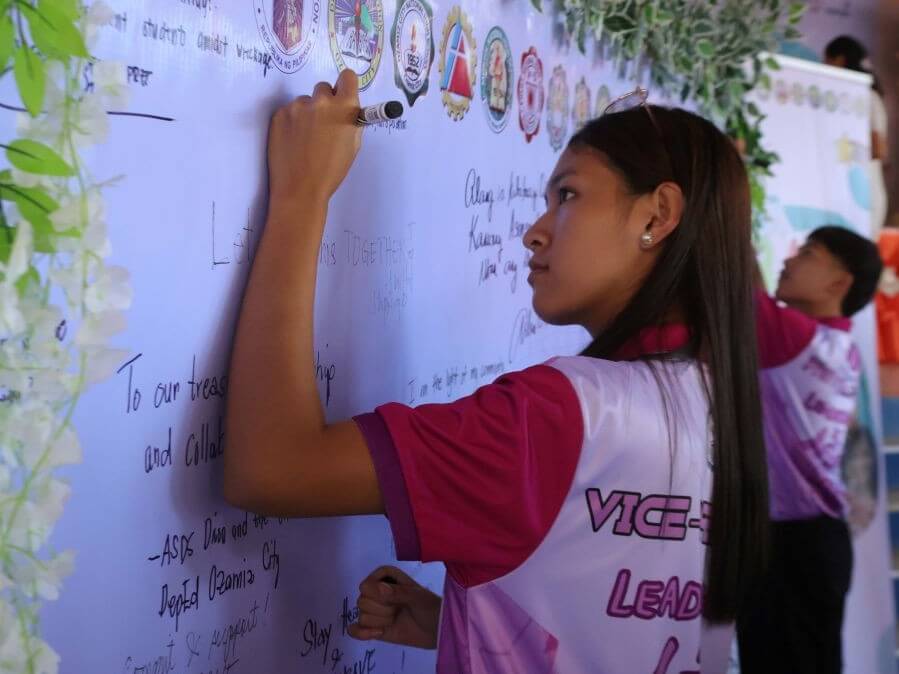 A student leader signs the Commitment Wall during the I AM BRAVE Call to Action ceremony. | Contributed photo 