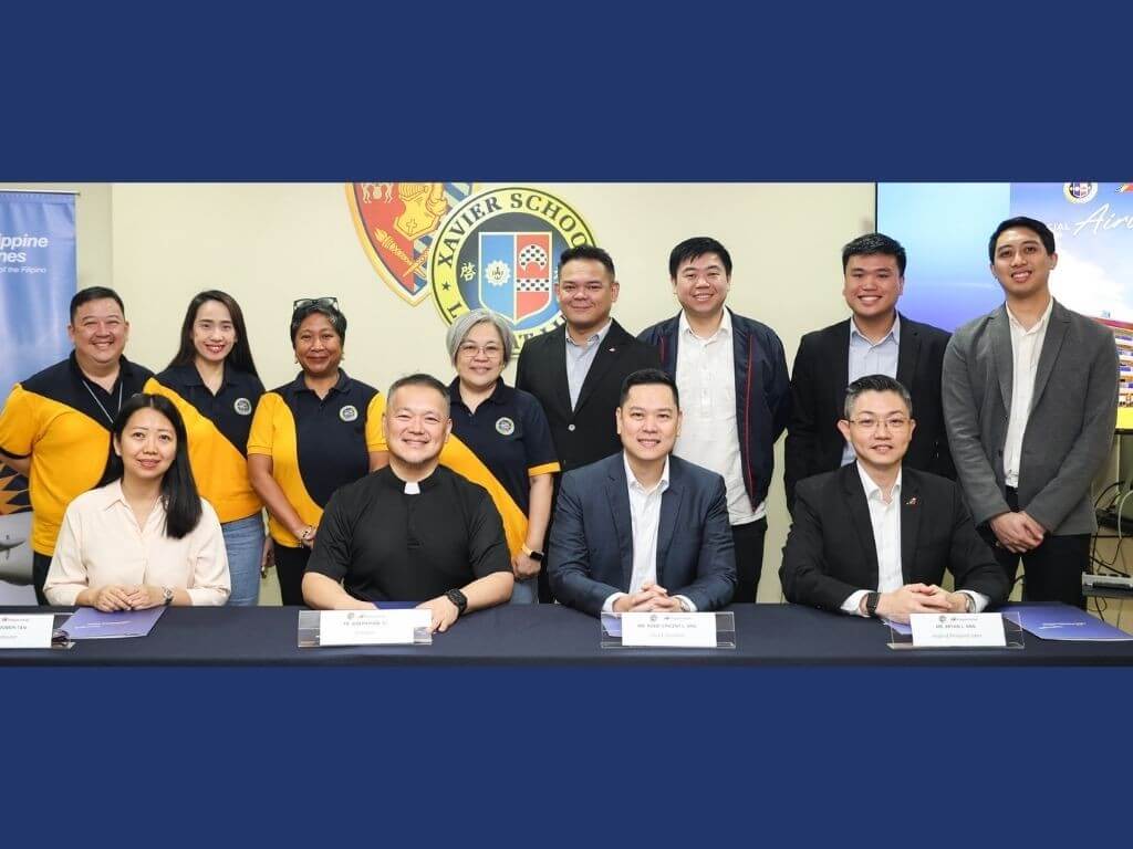 PAL Express president Rabbi Vincent Ang (third from left, seated) and Xavier School president Fr. Joseph Haw, SJ (second from left, seated) lead the signing ceremony for the partnership between Philippine Airlines and Xavier School, held at the Xavier School campus in San Juan. | Contributed photo