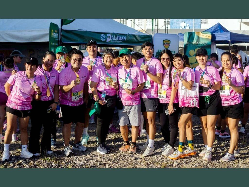 &nbsp;Bobby and Angelita Castro (fifth and sixth from left), founders of Palawan Group of Companies, share a light moment with women runners from the Naga City Women&rsquo;s Run. &nbsp;| Contributed photo