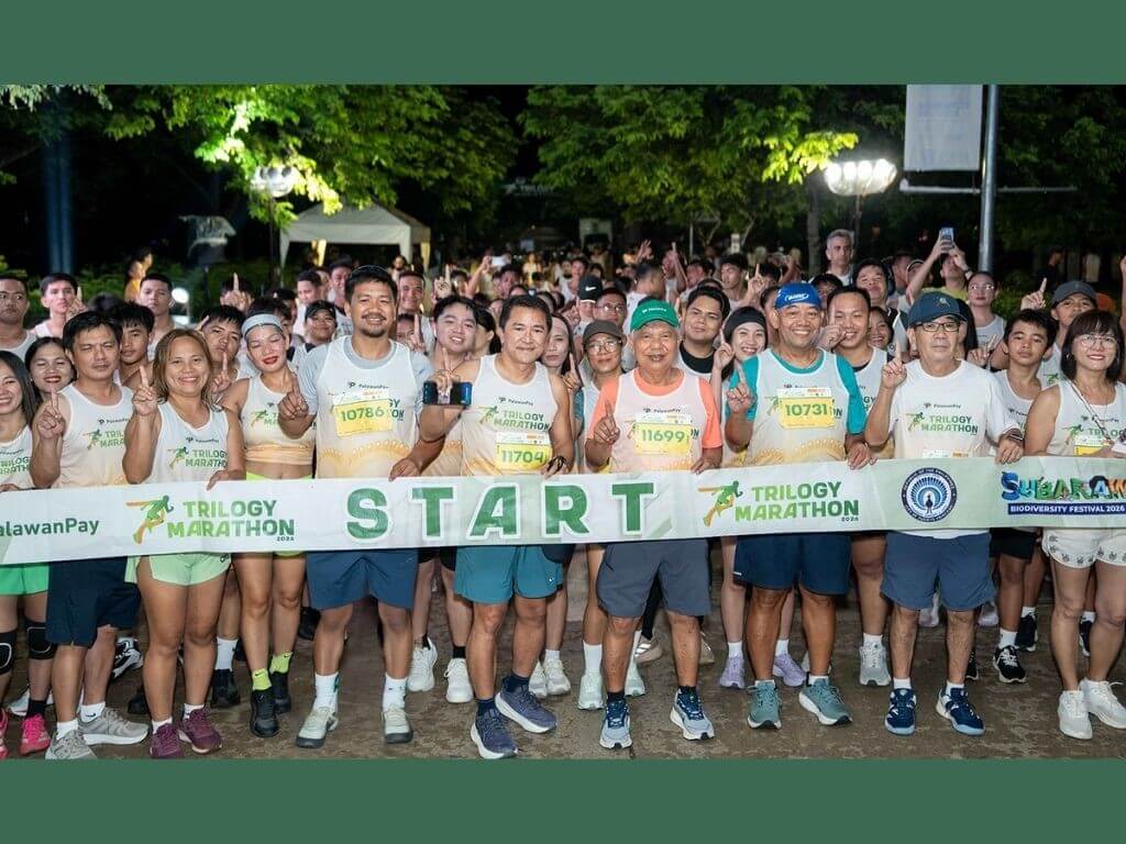 Palawan Group of Companies chair and founder Bobby L. Castro (wearing green cap) gathers with participants at the starting line of the PalawanPay Trilogy Marathon&rsquo;s Puerto Princesa leg on Oct. 18. | Contributed photo