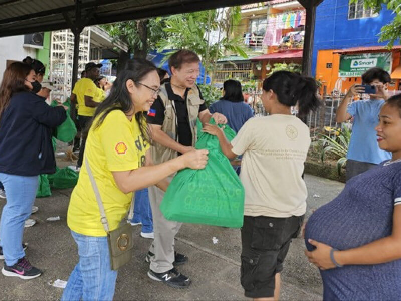 Shell volunteers and PDRF President Butch Meily distributing hygiene kits in the evacuationcenter in Rizal (Photo courtesy of PDRF) 