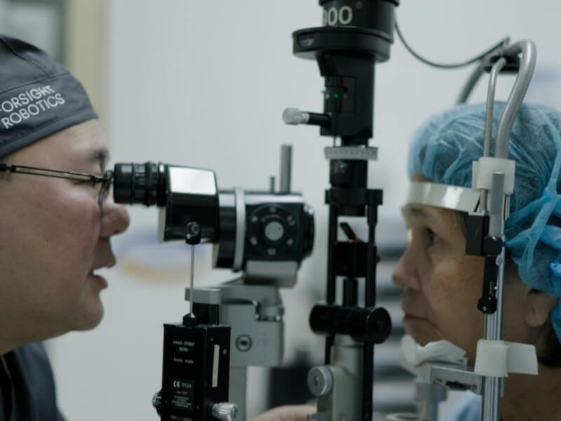 Dr. Robert Ang (left), serving as the study principal investigator, performs a post-op patient exam. | Photo courtesy: ForSight Robotics&nbsp; (Click to view full image)