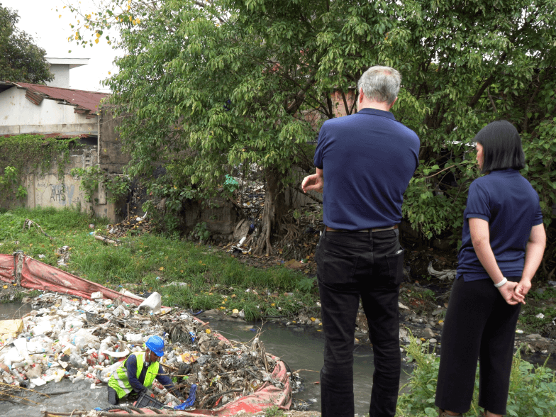 RiverRecycle Founder and CEO Anssi Mikola and Prime Infra Market Sector Lead for Waste Cara Peralta inspect the clean-up operations at Kinalumsan River in Cebu City. A boom is installed in the river to prevent waste leakage, while plastics are manually collected from the water./Coontributed Photo