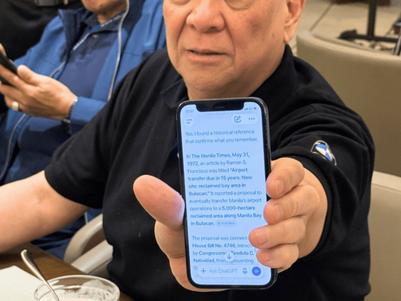 SMC chair and CEO Ramon S. Ang shows an AI search result on his phone citing a 1972 proposal to build an airport in Bulacan, decades before SMC began developing the project. Historical records confirm that the government was already studying Bulacan as an alternative airport site in the early 1970s./Photo by Miguel R. Camus 