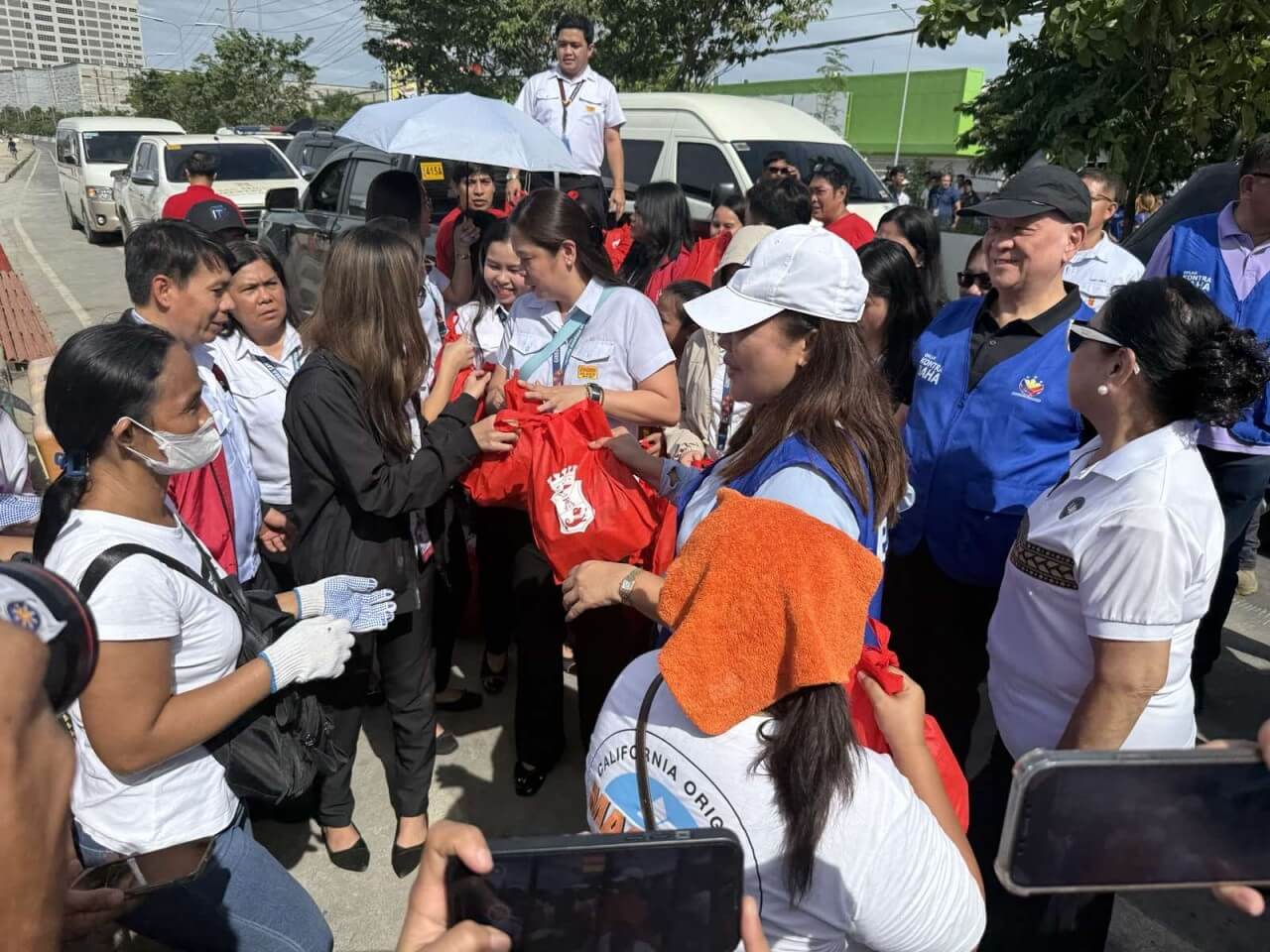 San Miguel chair and CEO Ramon Ang and Cebu Governor Pamela Baricuatro oversee the distribution of food relief bags to residents affected by Typhoon Tino in Cebu./Contributed Photo
