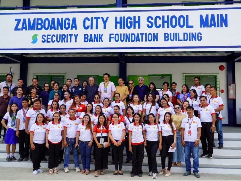 SBFI chair Rafael Simpao Jr. (11th from left, top row) and Security Bank EVP and branch banking group head Leslie Cham (10th from left, top row) lead the turnover of the Foundation&rsquo;s 900th classroom at Zamboanga City High School Main, reinforcing its nationwide education commitment. | Contributed photo