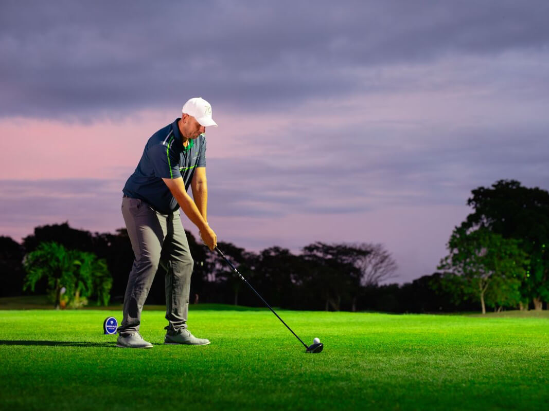 Rory Young, the club's director of golf, tees off at the launch of Night Golf at Mimosa Plus Golf Course./Contributed photo