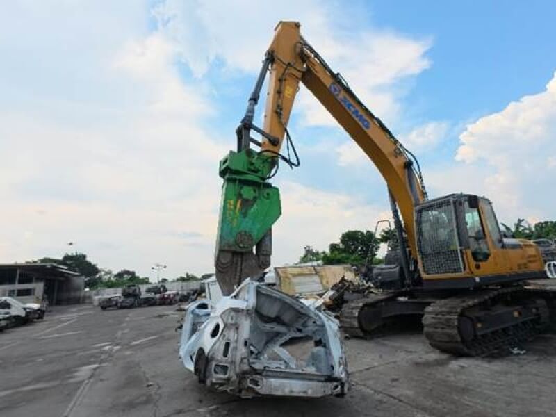 An excavator fitted with a hydraulic shear attachment dismantles an end-of-life vehicle at Standard Insurance's ELV (End-of-Life Vehicle) dismantling facility./ ​Photo from TMP