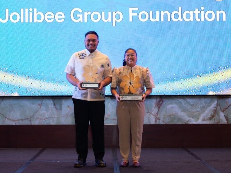 Jan Paolo Vicente, program manager, and Rebeka Paller, senior program officer, of Jollibee Group Foundation receive the Outstanding CSR Project in Enterprise Development award for the Foundation's Agri-Tech Facilitators Program during the 2026 League of Corporate Foundations CSR Guild Awards. | Contributed photo
