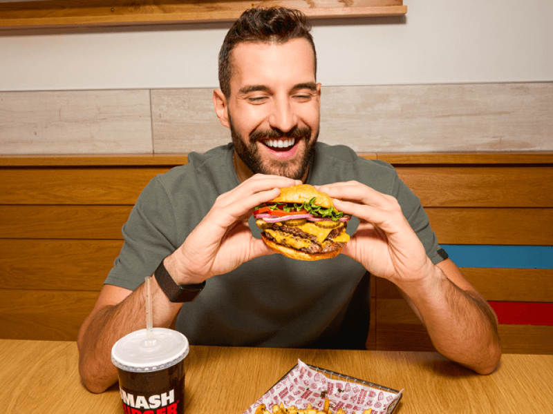 A guest enjoys a Smashburger meal as the fast-casual brand builds customer momentum. Smashburger posted 7% same-store sales growth in Q2 2026 and ranked No. 2 in the Reviewed Readers&rsquo; Choice Awards for Best National Burger Chain of 2026. | Contributed photo